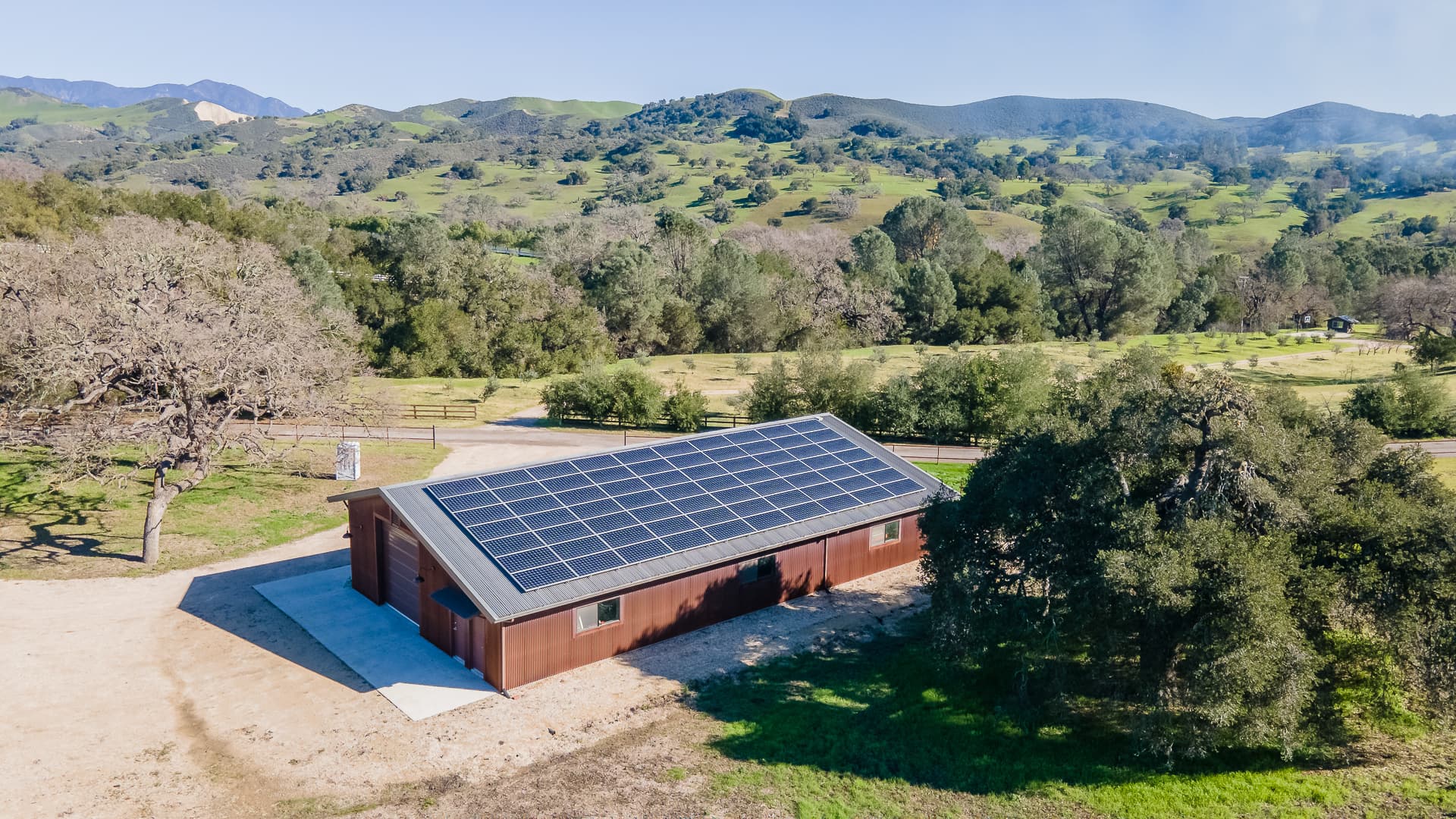 A Coast metal agricultural building set among the Central Coast’s rolling green hills